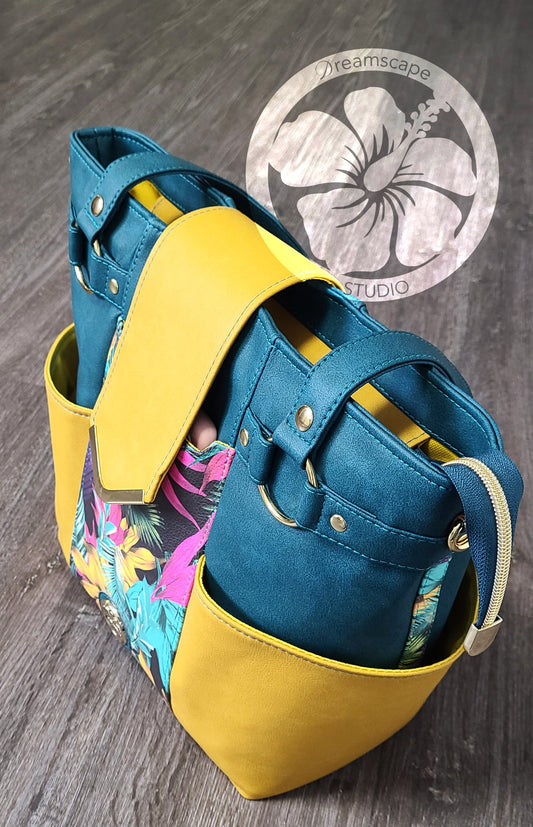 Mustard yellow vinyl, teal Mora faux leather, and custom floral vinyl on the Fallyn Bag by Kaya Papaya Design.